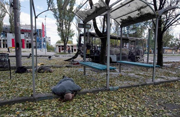 Жертви лежат на автобусна спирка в Донецк, ударена от снаряд.