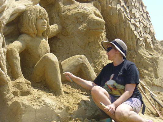 Доц. Ани Златева довършва фигурата на момченцето Маугли от "Книга за джунглата" на плажа в Бургас. 
