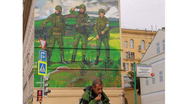 Руснак минава покрай графит, възхваляващ армията в Москва.
СНИМКИ: РОЙТЕРС