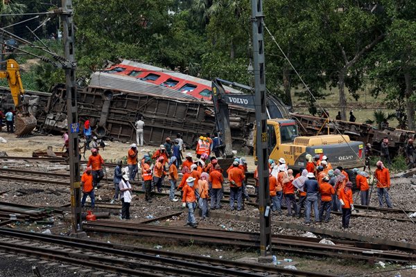 С тежка техника работници превестват повредени при голямата катастрофа вагони в източния щат Одиша, Индия. СНИМКА: РОЙТЕРС