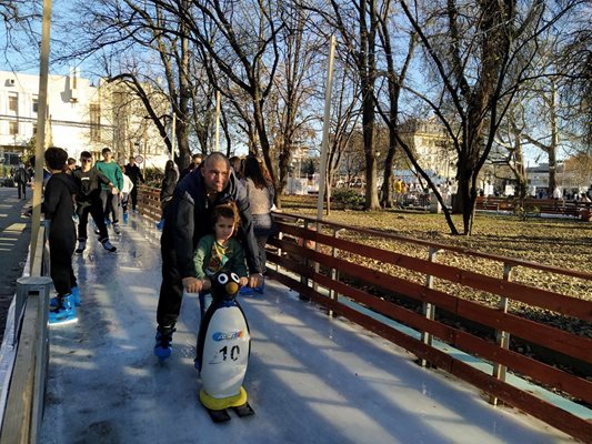 Родители се качват на пързалката заедно с децата си, за да им помагат сред навалицата.