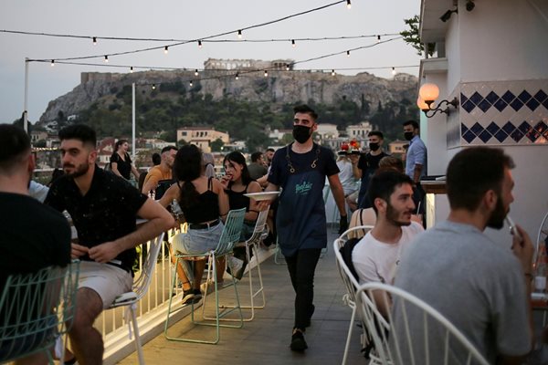 Келнер с маска сервира в бар в Атина. 
СНИМКИ: РОЙТЕРС