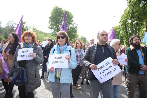 Служители на БНР протестират с плакати в ръка.