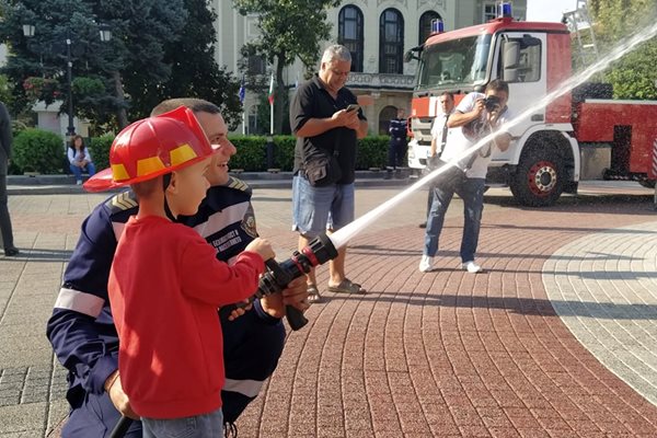 Огнеборец показва на момченце как се гаси. Снимки: Авторът
