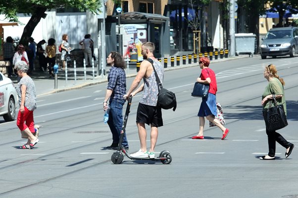 Мъж на тротинетка пресича на зелен светофар с пешеходците в София