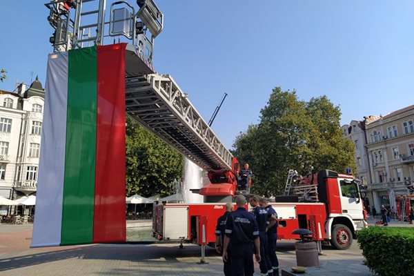 Националното знаме се вее от стълбата на противопожарен автомобил.
