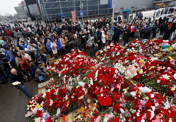 People gather and lay flowers at a makeshift memorial in the Moscow region for the victims of the concert hall attack 