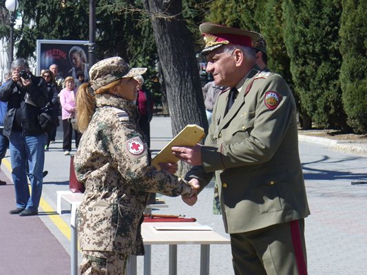 Началникът на отбраната генерал-лейтенант Андрей Боцев награждава медик от контингента.