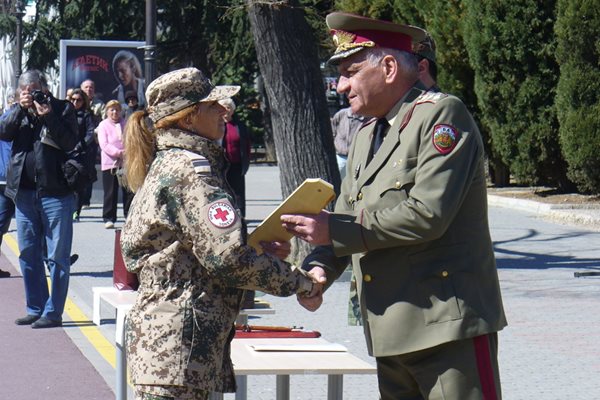 Началникът на отбраната генерал-лейтенант Андрей Боцев награждава медик от контингента.