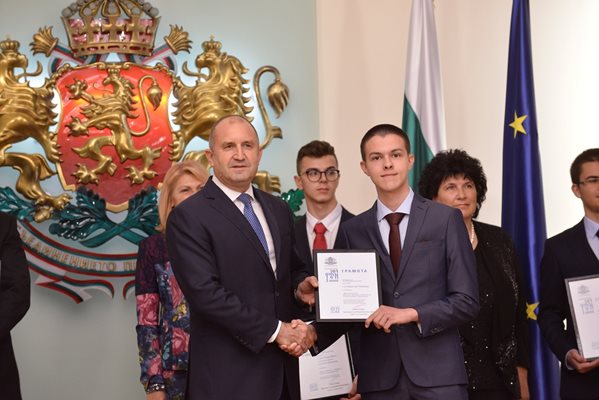 Румен Радев връчва награда на  Радостин Чолаков.