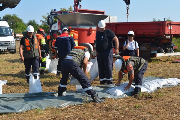 Екипи на пожарната и доброволци изграждат пясъчна дига, за да спрат прииждащите води на р. Росица.

Снимки: Община Павликени