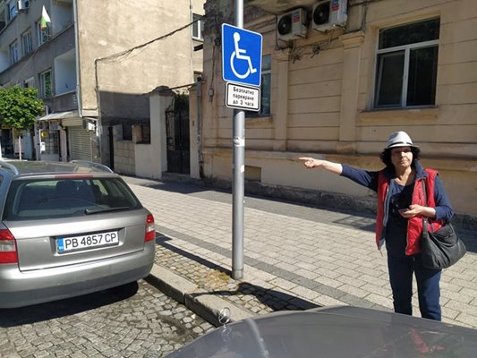 Пенсионерката Евгения Петрова пази колата да не бъде санкционирана, докато съпругът и?, който е с решение на ТЕЛК, е в централната поща за пенсията. Мястото за инвалиди е заето и мъжът е спрял на друго, което не е отредено за хора с увреждания.