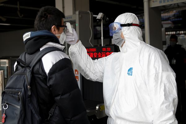 Медицински работник проверява температурата на пътник на летището в град Чанша.