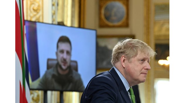Премиерът на Великобритания Борис Джонсън слуша видеообръщението на Володимир Зеленски на срещата на Обединените експедиционни сили. Снимка РОЙТЕРС