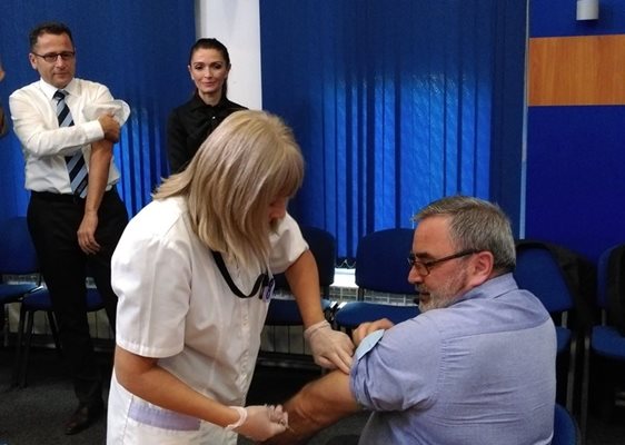 Главният държавен здравен инспектор д-р Ангел Кунчев се ваксинира срещу грип след дискусия за профилактиката, вляво изчаква реда си ръководителят на офиса на Световната здравна организация за България д-р Скендер Сила.