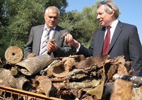 2009 г. Валентин Радев и тогавашният американски посланик Джеймс Уорлик пред купищата гилзи и парчета от взривени снаряди в района на складовете край Челопечене.
