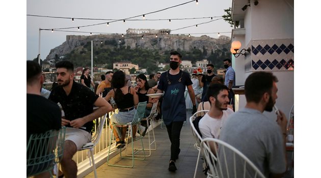 Келнер с маска сервира в бар в Атина. 
СНИМКИ: РОЙТЕРС