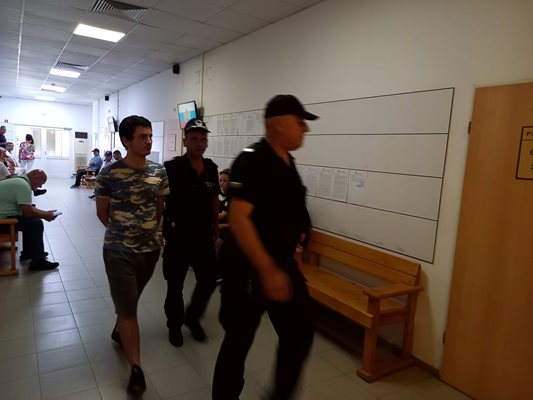 Полицаи въвеждат Станислав Огнянов в съдебната зала.