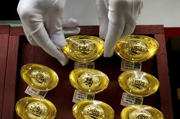 Продавач подрежда изделия от злато в магазин в Китай. Цената на благородния метал се качва, а прогнозите сочат че може да стигне скоро 1600 долара.