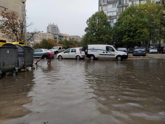 Младеж отпушва с ръце шахта на ул. "Белица", която прилича на езеро. Снимки: Авторът