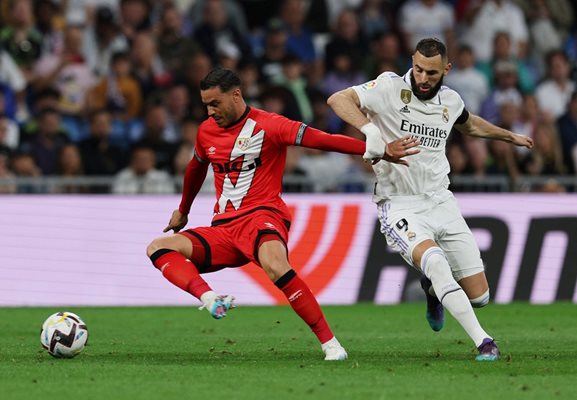 Нападателят на "Реал" Карим Бензема (вдясно) се бори за топката с Раул де Томас ("Райо Валекано") в последния шампионатен мач от Ла Лига, завършил 2:1 за "белите". Снимка: Ройтерс