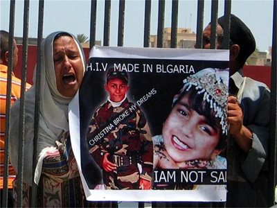 Родители на заразени деца в Бенгази държат плакат с надпис: "Вирусът на СПИН, произведен в България". 
СНИМКА: ГЕОРГИ МИЛКОВ
