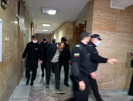 Полицаи водят Стоян Янев към съдебната зала.
СНИМКА: Авторът
