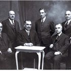 ЗАГАДКА: Възможно е на тази снимка на видни наши финансисти от 2 август 1938 г. да е и Анжело Куюмджийски, тъй като е документирано, че е присъствал на повода, по който тя е правена. Повечето от лицата на нея са известни - долу седнали от ляво надясно са Добри Божилов, Стефан Бочев и Марко Рясков, а горе вдясно е Стойчо Мошанов. Редакцията се обръща с молба към читателите, които могат да го разпознаят или притежават негов портрет да ни пишат на press168chasa@abv.bg