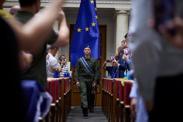 Членове на почетната гвардия носят знамето на ЕС в заседателна зала на украинския парламент, докато президентът на Европейската комисия Урсула фон дер Лайен изнася реч пред депутатите чрез видеовръзка.
Снимка: Ройтерс