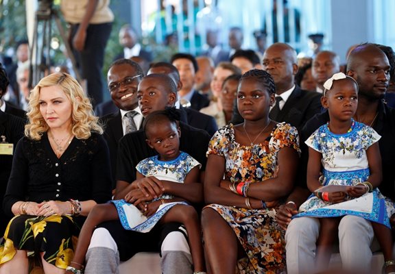 Певицата Мадона с три от общо шестте си деца по време на посещение в Малави. Тя често разчита на мъже, които да й помагат да се грижи за тях.