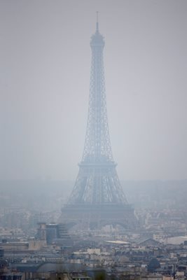 Силуетът на Айфеловата кула едва се вижда от смога в Париж през март 2014 г., когато Франция наложи най-драстичните ограничения за коли от 20 г.

