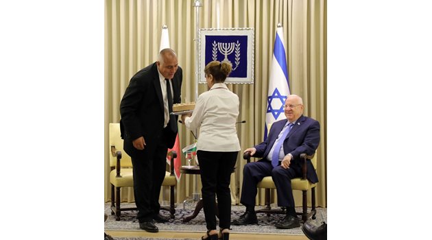 Служителка на израелското президентство внася тортата за рожденика