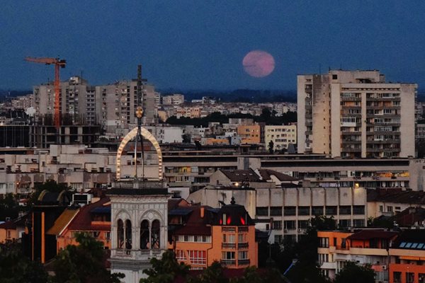 Цветната Супер Луна изгрява зад камбанарията на Католическата катедрала. 