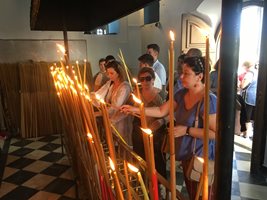 Богомолци палят свещи пред иконата на Богородица.