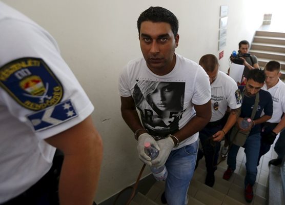 Арестуваните за трафика на имигрантите влизат в съда в Кечкемет под полицейска охрана.