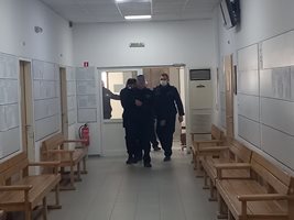 Под засилена охрана полицаят и съучастниците му бяха докарани в съда