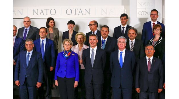 Шефът на НАТО Йенс Столтенберг (в средата) позира с военни министри от страните в пакта на срещата в Брюксел.