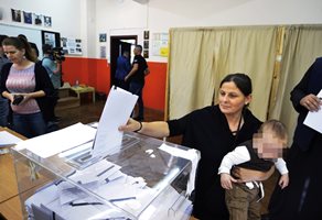 Избирателка пуска бюлетината си в урната.