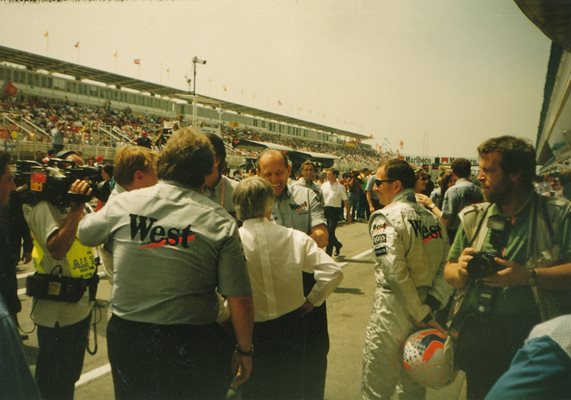 Собственикът на Формула 1 Бърни Екълстоун (в гръб с бялата риза) поздравява шефа на "Уест Макларън Мерцедес" Рон Денис с двойната победа. Вляво леко се вижда и Мика Хакинен. Снимка: Авторът