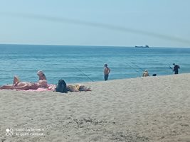 Рибари и плажуващи си съжителстват мирно на плажа на хижа “Черноморец” край Варна.
