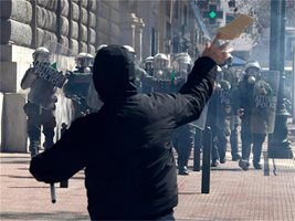Протестиращ младеж хвърля камъни срещу полицейския отряд за борба с безредиците по време на вчерашните сблъсъци в центъра на Атина. Хиляди протестираха срещу правителствената програма за строги икономии. 
СНИМКИ: РОЙТЕРС