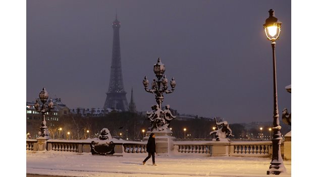 Жителка на Париж отива на работа по тъмно в студена зимна утрин.