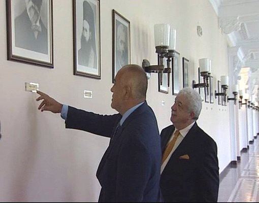 Борисов и Гусман разглеждат портретите на българските премиери в коридора пред заседателната зала на Министерския съвет.
