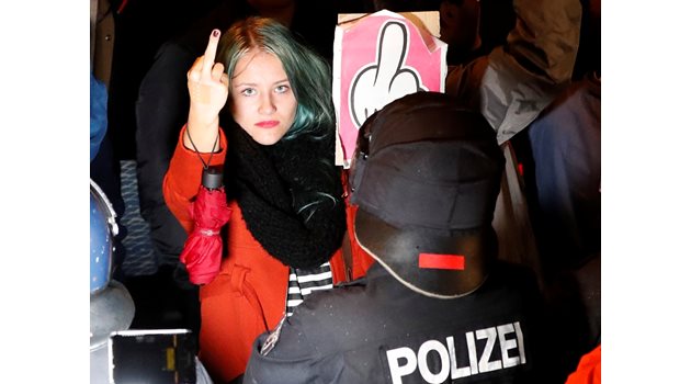 Демонстрантка срещу крайнодесните показва среден пръст в знак на протест пред щаба им в Берлин в неделя. СНИМКИ: РОЙТЕРС
