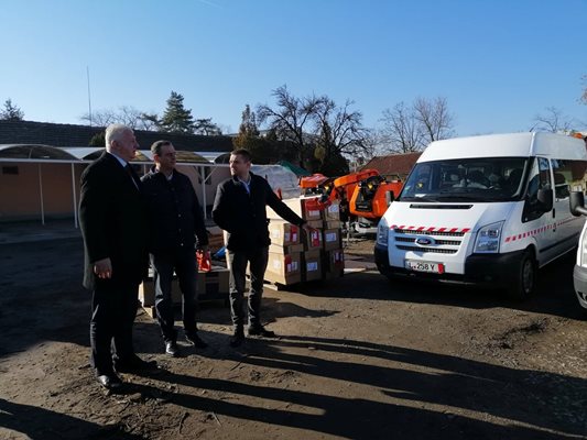 Веселин Козарев (вдясно) показва на кмета новозакупените бусове, с които ще возят работниците по градините и парковете из града.