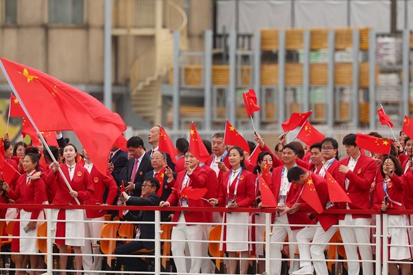 Chinese athletes wave flags during the athletes' parade along the Seine River Photo: Reuters