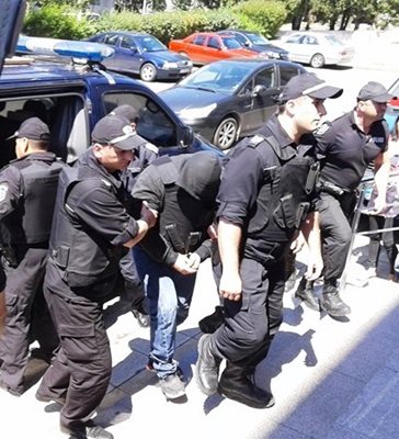 Тежко въоръжени полицаи водят стрелеца Тодор Славов в Бургаския окръжен съд. Снимка:Елена Фотева