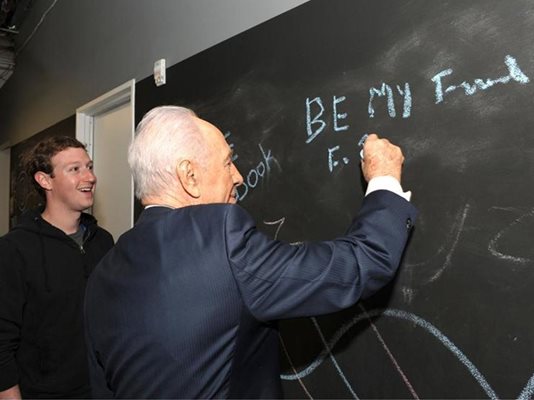 Израелският президент Шимон Перес пише по черната дъска заедно с основателя на фейсбук Марк Зукърбърг при посещение в централата на социалната мрежа в Калифорния.