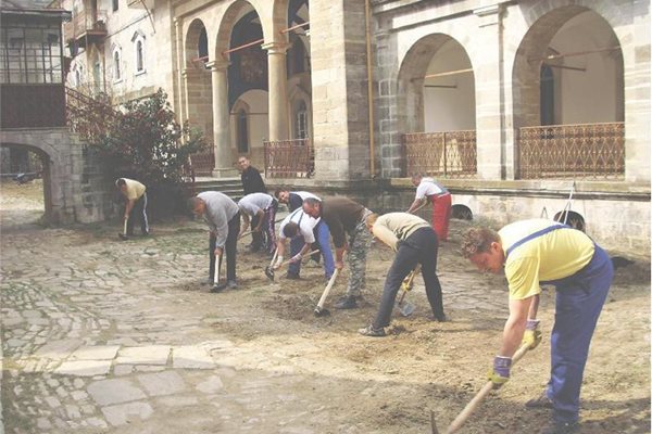 Доброволци от Банско засаждат дръвчета в двора на Зографския манастир. 
СНИМКА: ЛИЧЕН АРХИВ