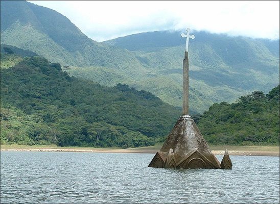 Само върхът на църквата в Потоси, Венецуела стърчи от водата, след построяване на стената на язовира, в който тя попада.